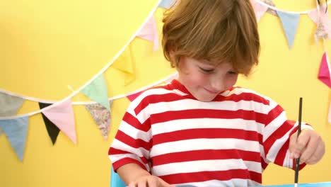 happy boy using a paint brush