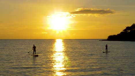 Silhouette-Eines-Paddelbretts-Im-Meer-Bei-Sonnenuntergang,-Goldene-Stunde