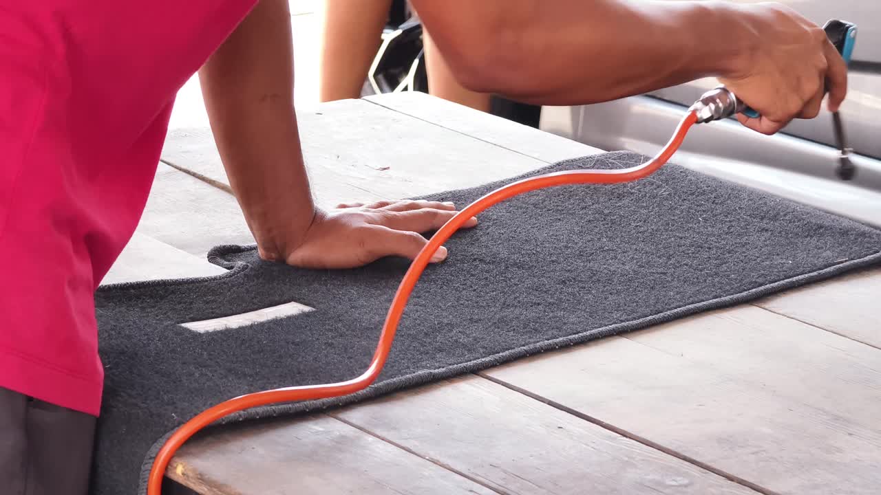 Cleaning car floor mats with air compressor