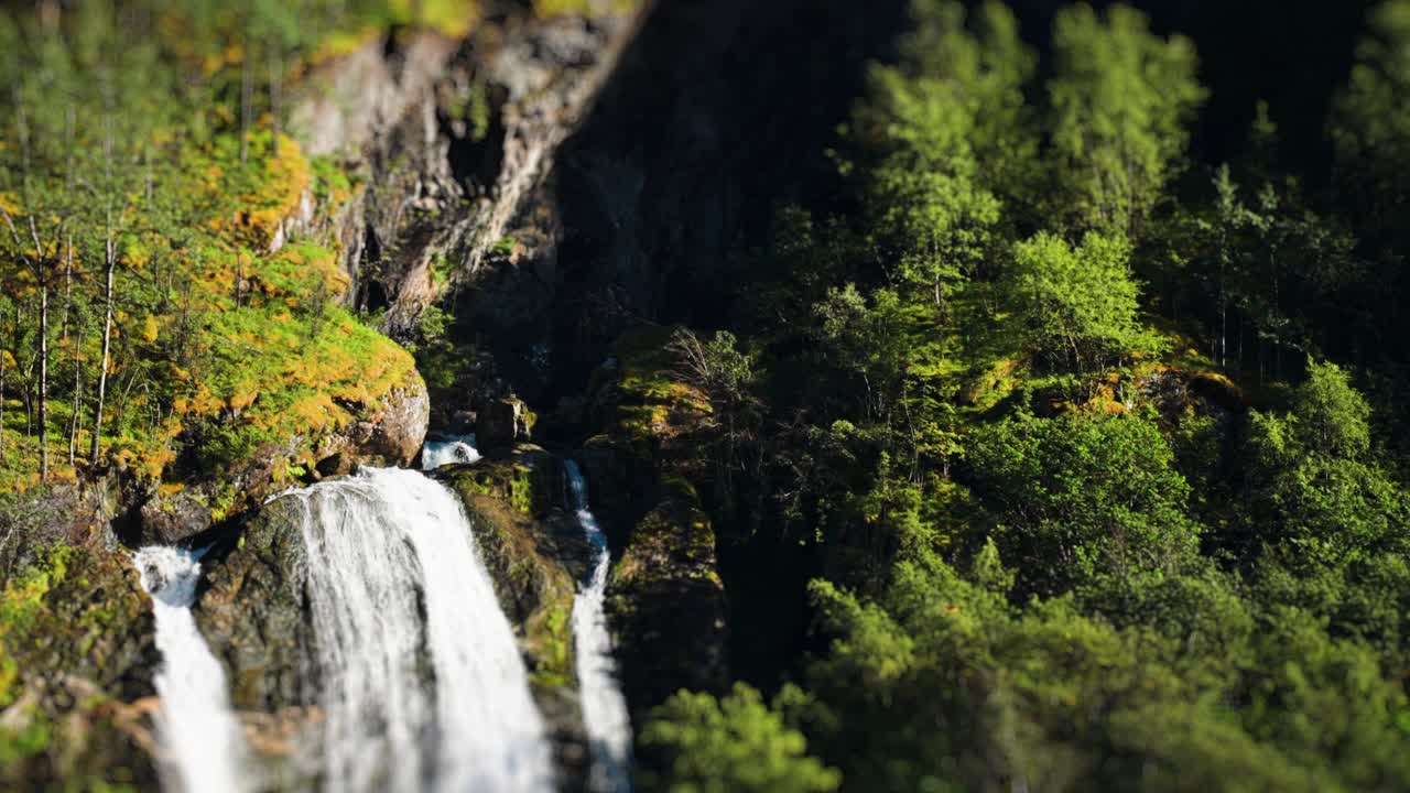 A tilt-shift video of the waterfall on the forest-covered shores of the Naeroy Fjord
