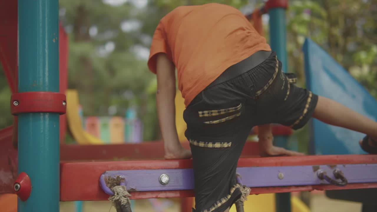 Little Boy Wearing a Face Mask Enjoying the Slide at the Playground, Goa India