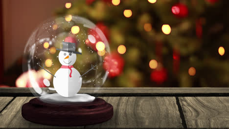 Animation-of-snow-globe-with-snowman-on-wooden-table-over-christmas-tree