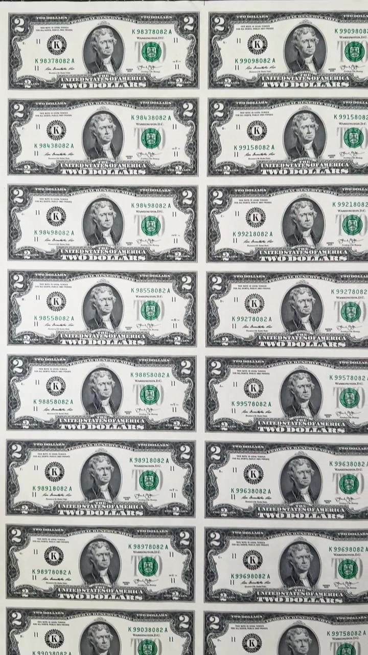 Rows of Thomas Jefferson portraits on uncut two dollar bills. Full frame background of an uncut sheet of US 2 dollar banknotes.