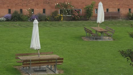 folded sun umbrella moved by wind placed over tables in common living area