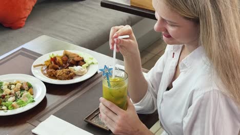 woman enjoying a drink and meal at a restaurant