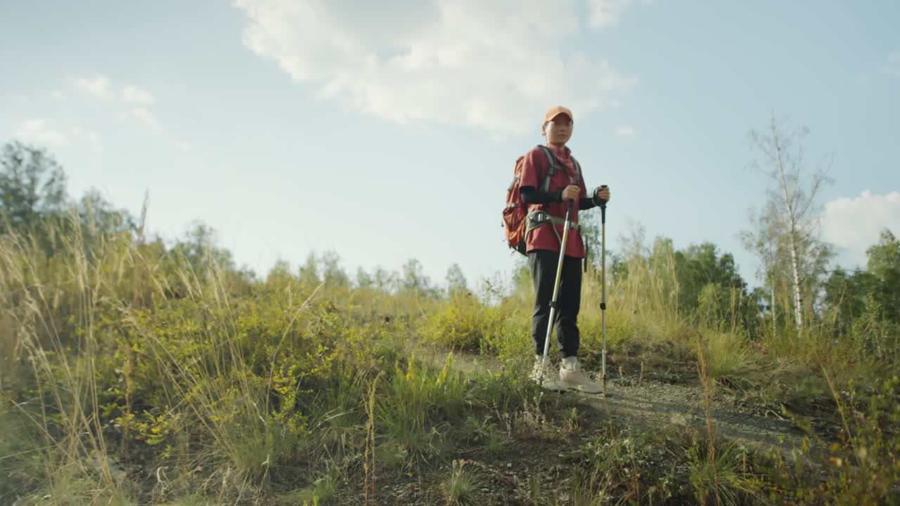 Asian Female Tourist Hiking with Trekking Poles