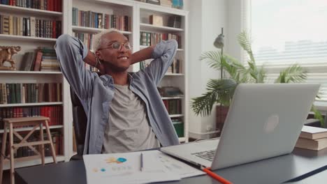calm african man in glasses relax at home office workplace take nap or daydream