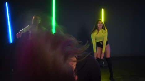 tres mujeres bailando en luces de neón