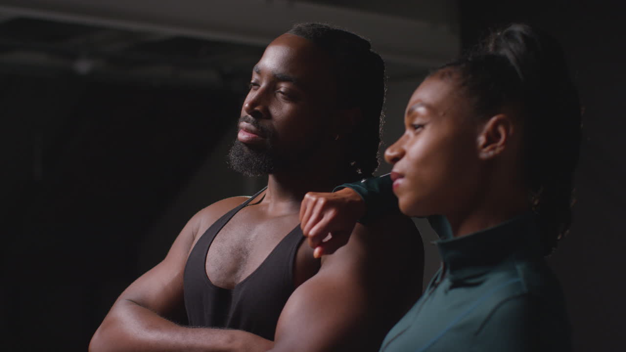 Studio Portrait Of Smiling Athletic Couple Or Friends In Fitness Clothing Training Shot In Gym With Low Key Lighting 4