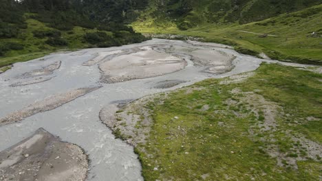 wide angle drone video of the beautiful mountains in northern italy with a giant waterfall and river. near the dolomites in south tyrol