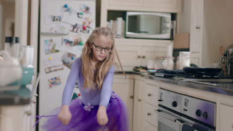 una bailarina feliz bailando en la cocina con un tutu púrpura divirtiéndose realizando movimientos de baile divertidos disfrutando de la celebración del fin de semana en casa