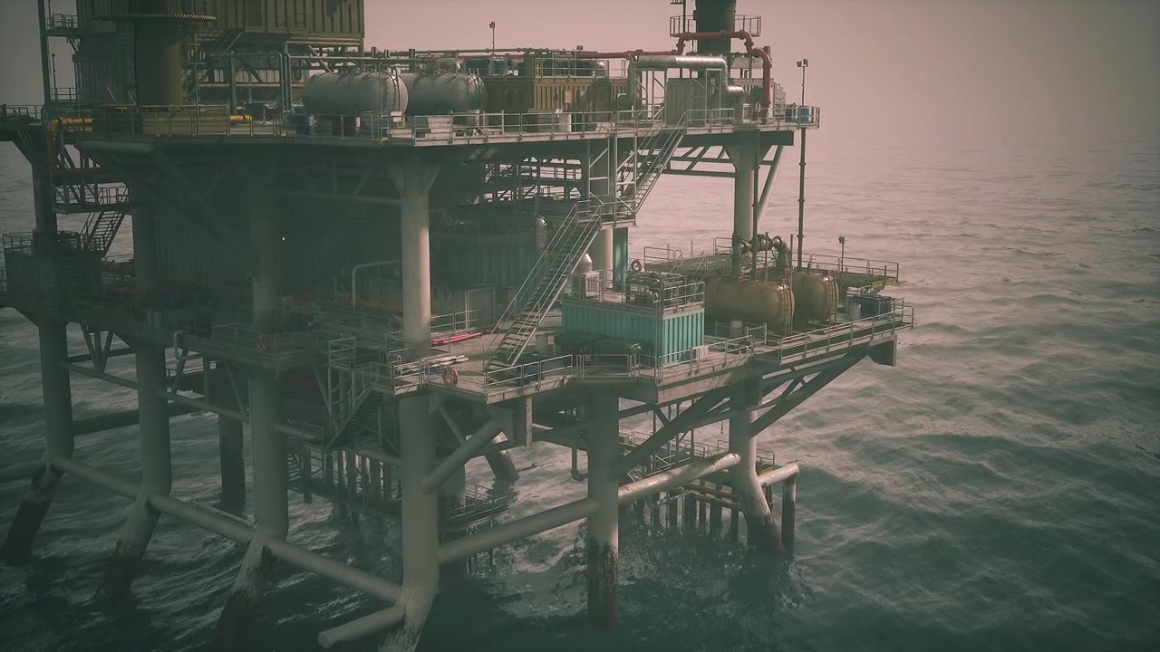 Oil rig stands tall above tranquil sea during late afternoon light