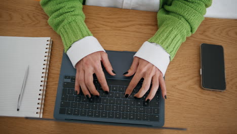 mujer irreconocible trabajando con una computadora portátil en casa de cerca. manos de dama escribiendo en la computadora