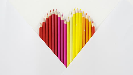 Colored-pencils-arranged-in-heart-shape-on-white-background