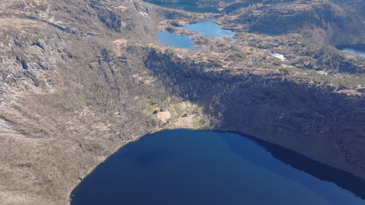 Drone circling above Kringlebotn mountain farm in Matrefjellene, capturing the old buildings and the panoramic mountains