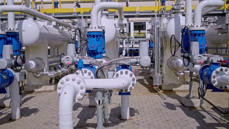 industrial gas pipeline station with valves, tanks and metal pipes in bright daylight