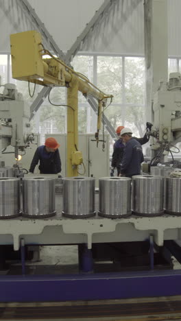 industrial workers operating heavy machinery in a factory