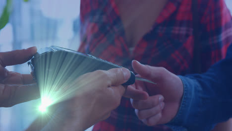 animación de puntos de luz sobre pareja caucásica pagando con tarjeta de crédito