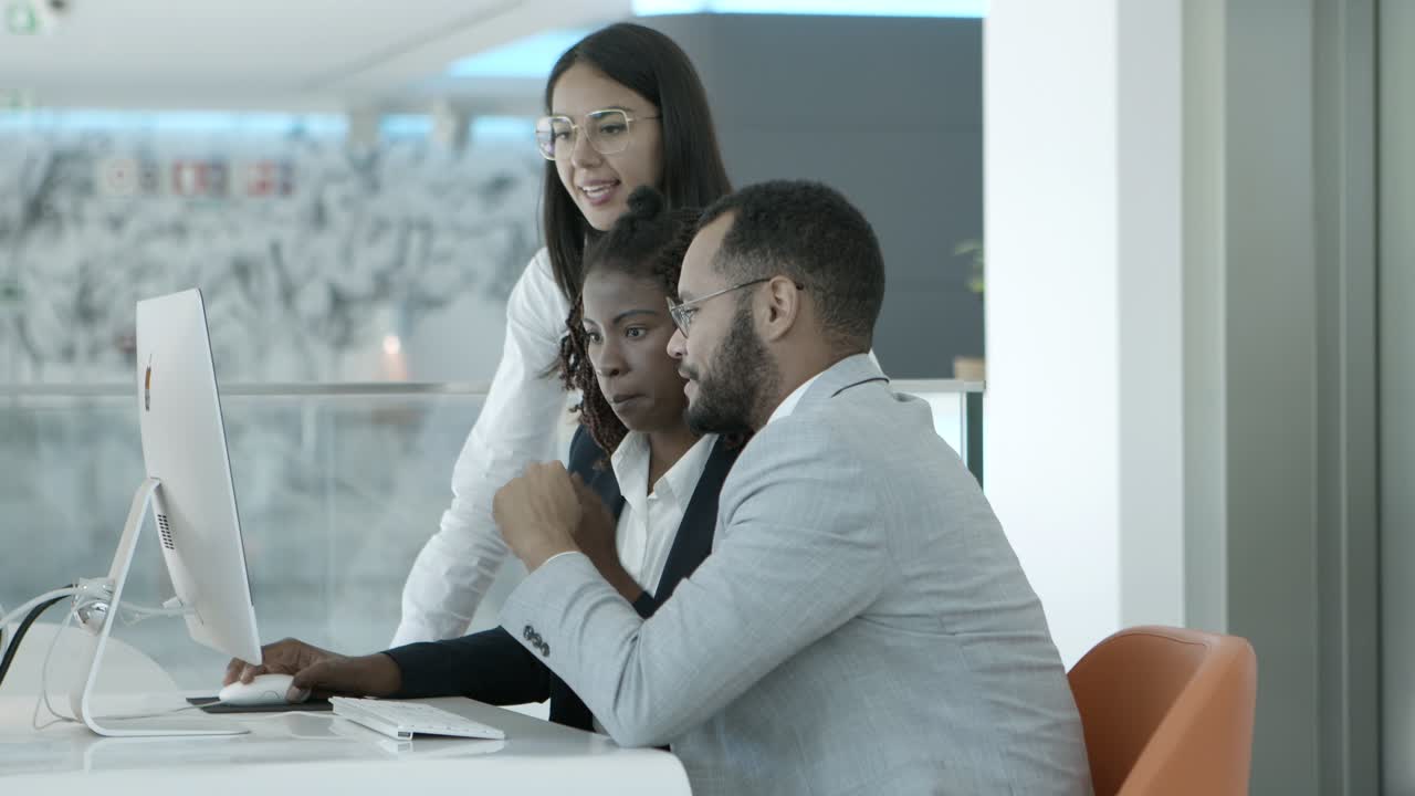 colegas multiétnicos que usan computadoras de escritorio