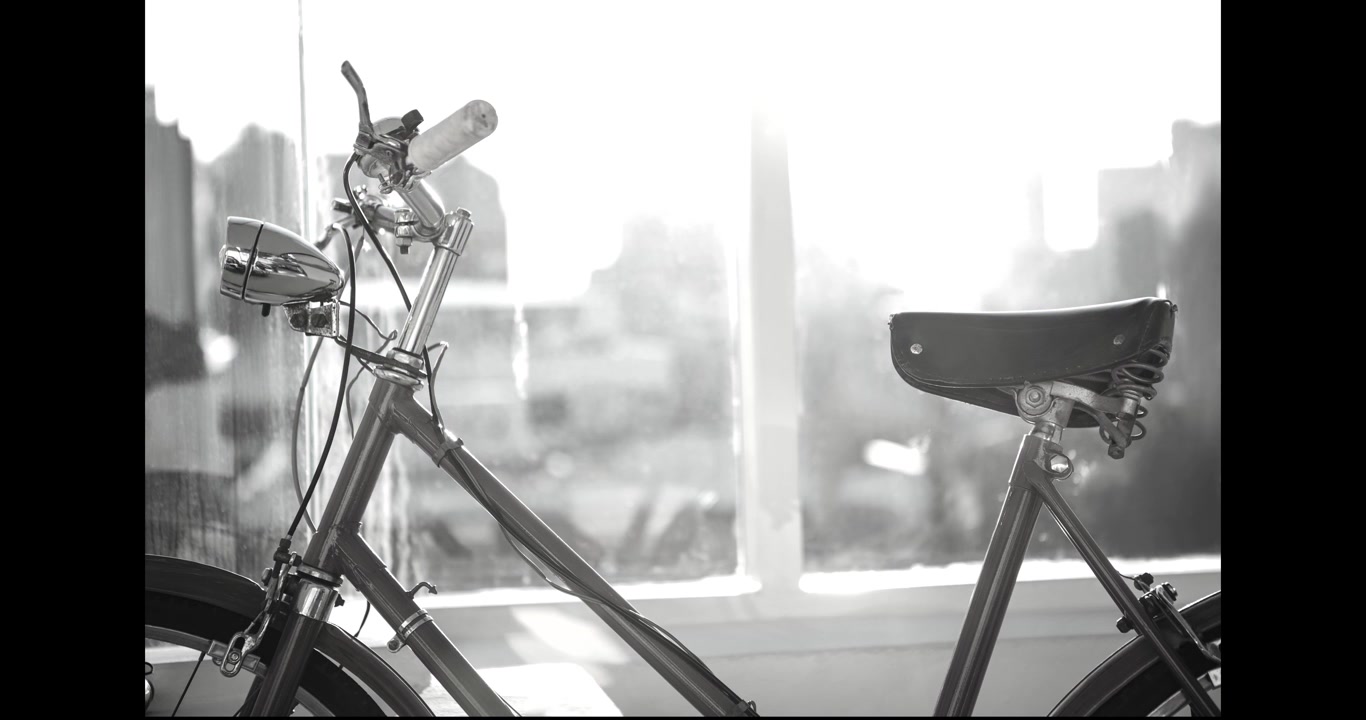 Animazione di forme su una bicicletta in bianco e nero e un paesaggio urbano.
