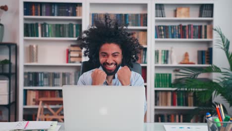 overjoyed emotional arabian man starts to shout and rejoice looking at laptop