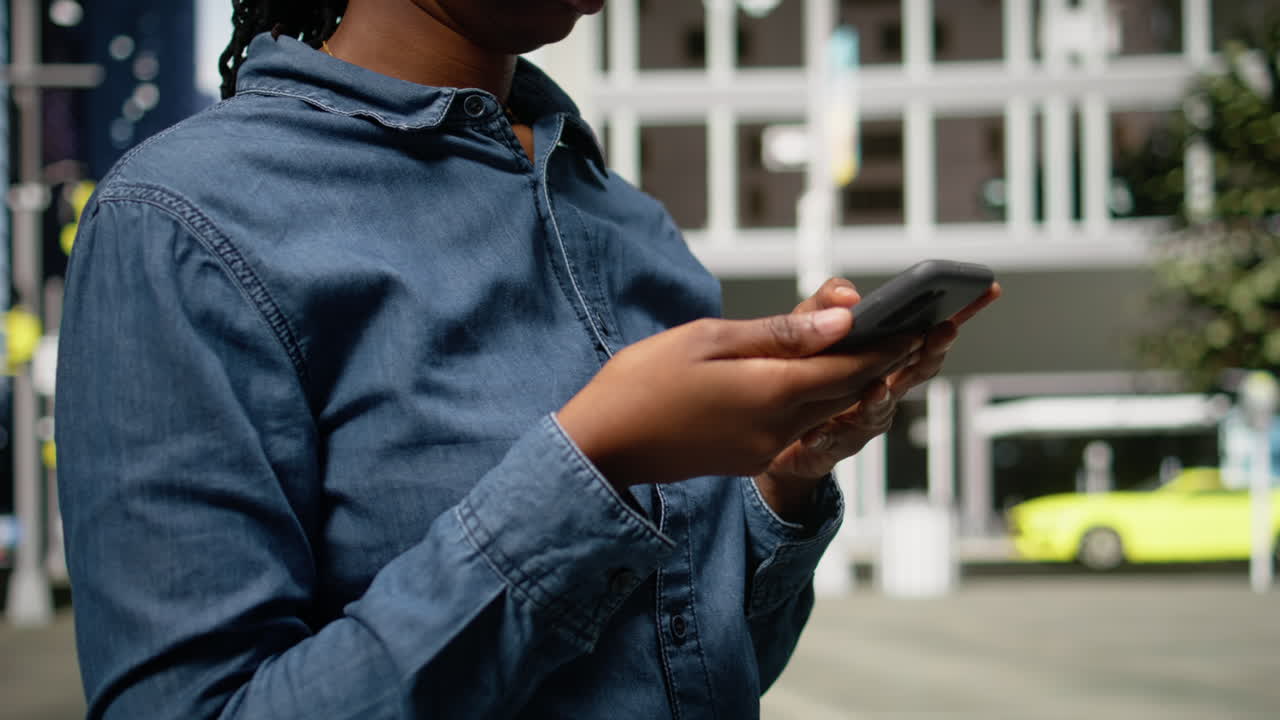 Primo piano di una donna di colore che usa lo smartphone per ottenere indicazioni stradali su un'app