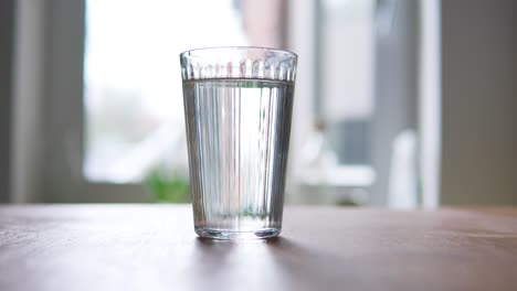 colocando un vaso de agua frente a una ventana