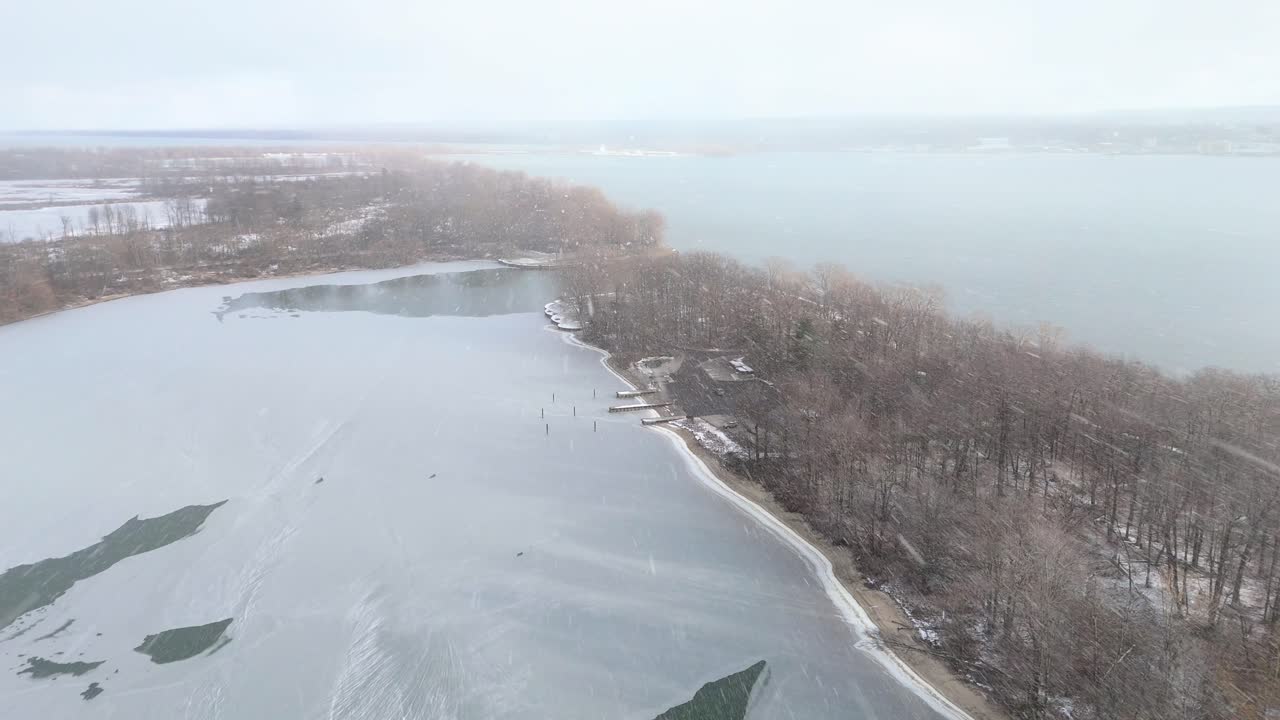 Wide aerial shot of snow falling over Presque Isle State Park in Erie, Pennsylvania.