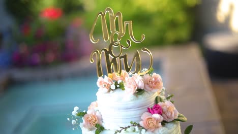 Smooth-shot-of-a-beautifully-decorated-wedding-cake-on-a-fancy-platter-at-a-wedding-reception