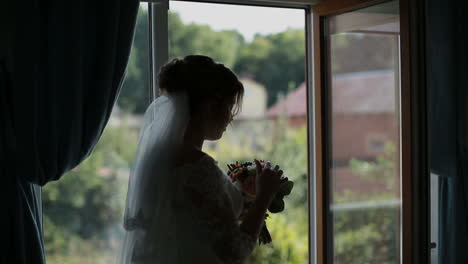 beautiful bride stands by the window. wedding bouquet