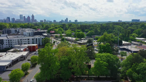 Aerial-of-Atlanta-suburbs-with-natural-green-areas-and-Downtown-Atlanta-skyline-and-skyscrapers-in-background,-Georgia,-USA