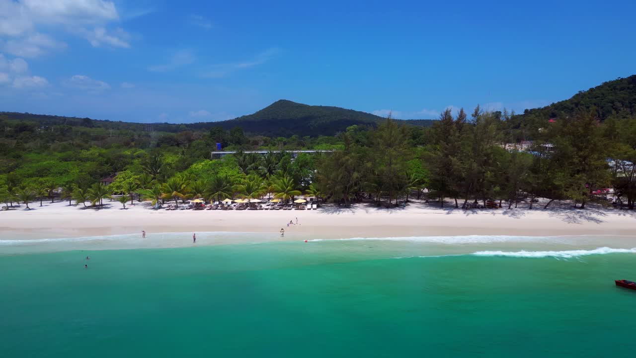 tropical Hut on white sand beach meeting calm turquoise water in Koh Rong island, Cambodia. Fantastic aerial view flight panorama overview drone