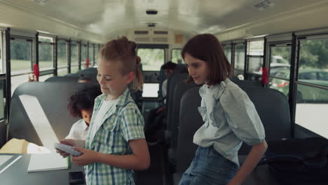 preteen classmates playing talking in school bus. teen kids waiting riding home.