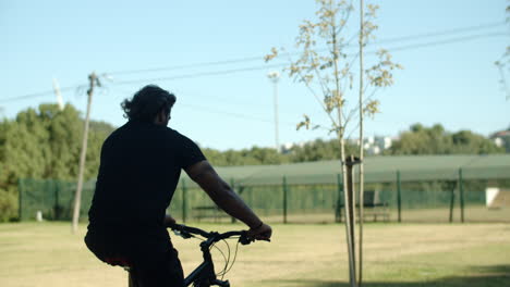 long shot of man with disability riding bike down stairs