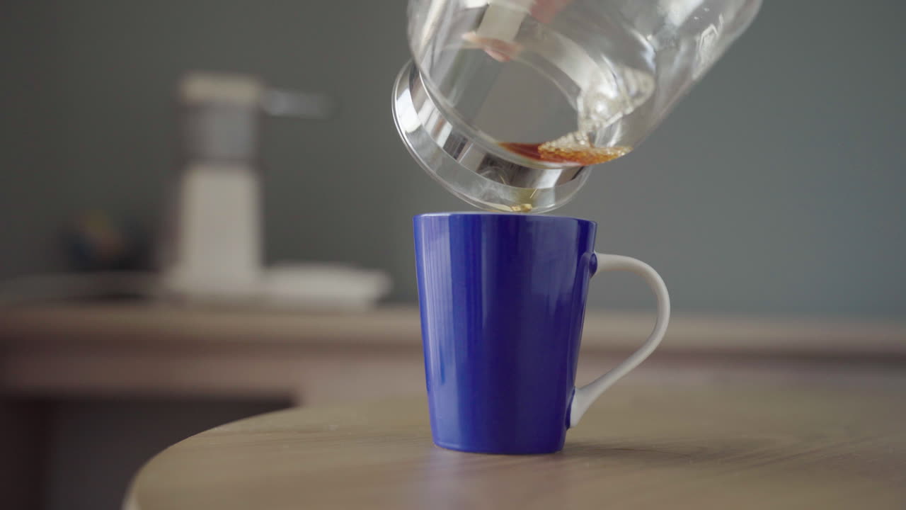 파란색 컵에 커피를 붓는다