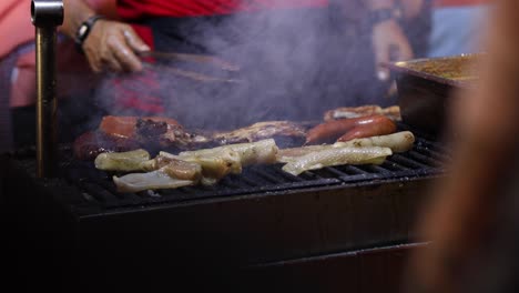 street food. pork meat and sausages being cooked over hot charcoal fire