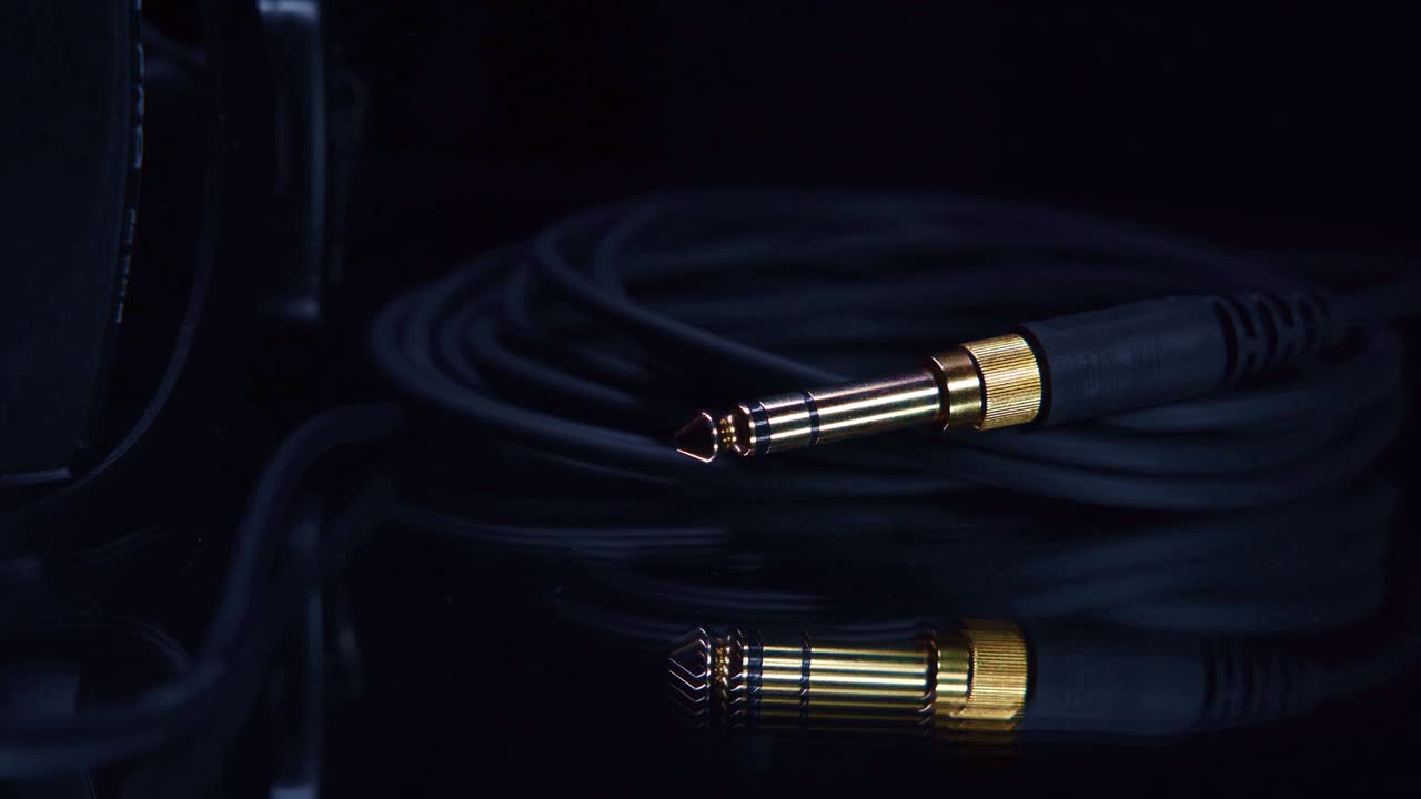 어두운 환경에서 케이블과 함께 황금 스테레오 헤드폰 잭