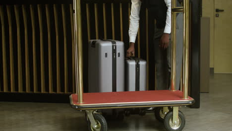 bellhop loading luggage onto a cart at the hotel