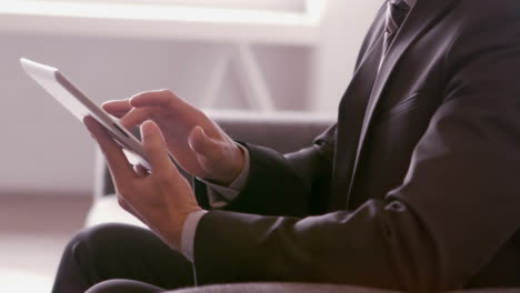 businessman using tablet on sofa