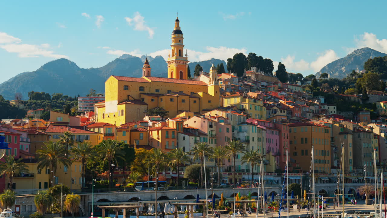 Distant view of the St Michel Basilica surrounded by colourful buildings, Menton, France