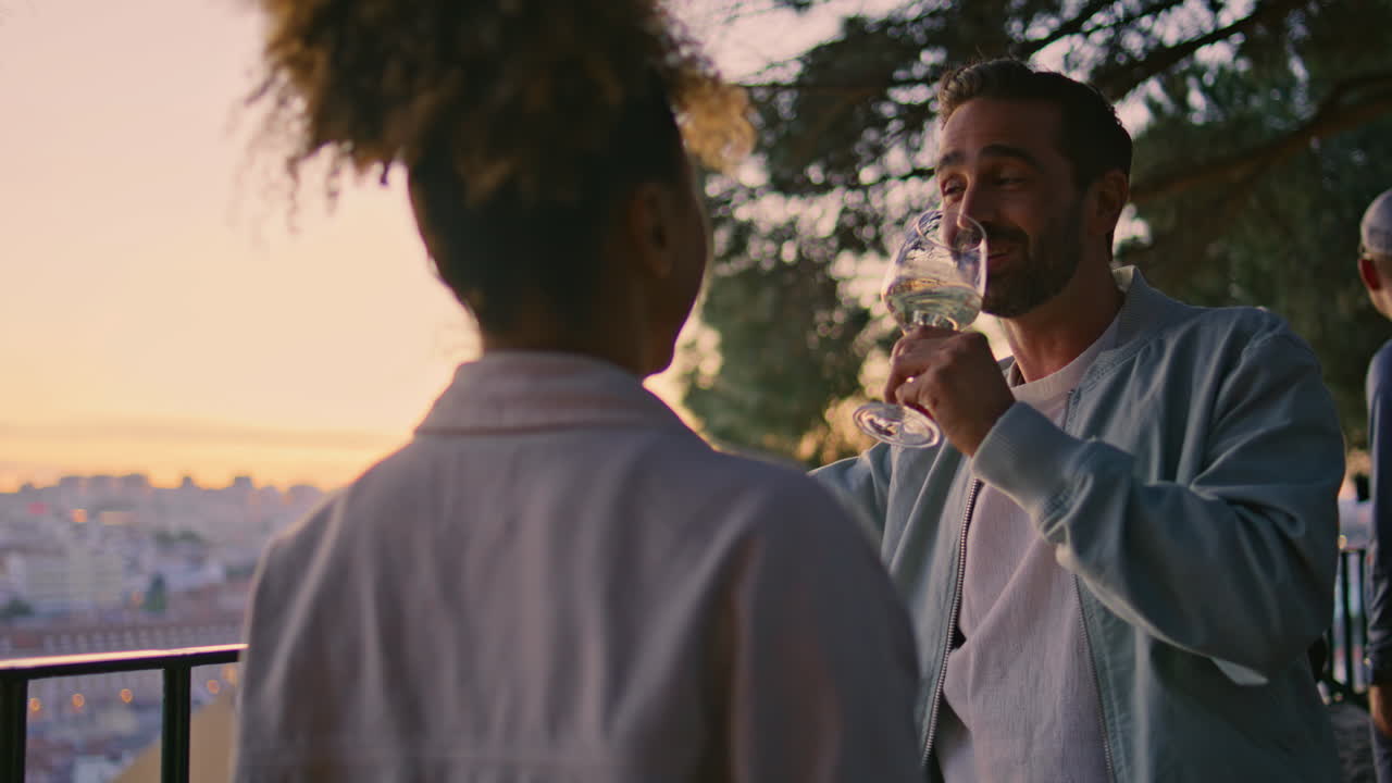 Primo piano di una coppia che flirta e si gode il vino al tramonto da un punto panoramico. Coppia che beve alcol.