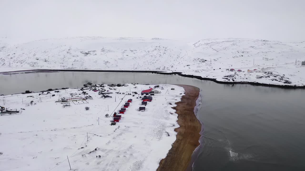강변 에 있는 은 오두막 을 가진 눈 인 북극 마을
