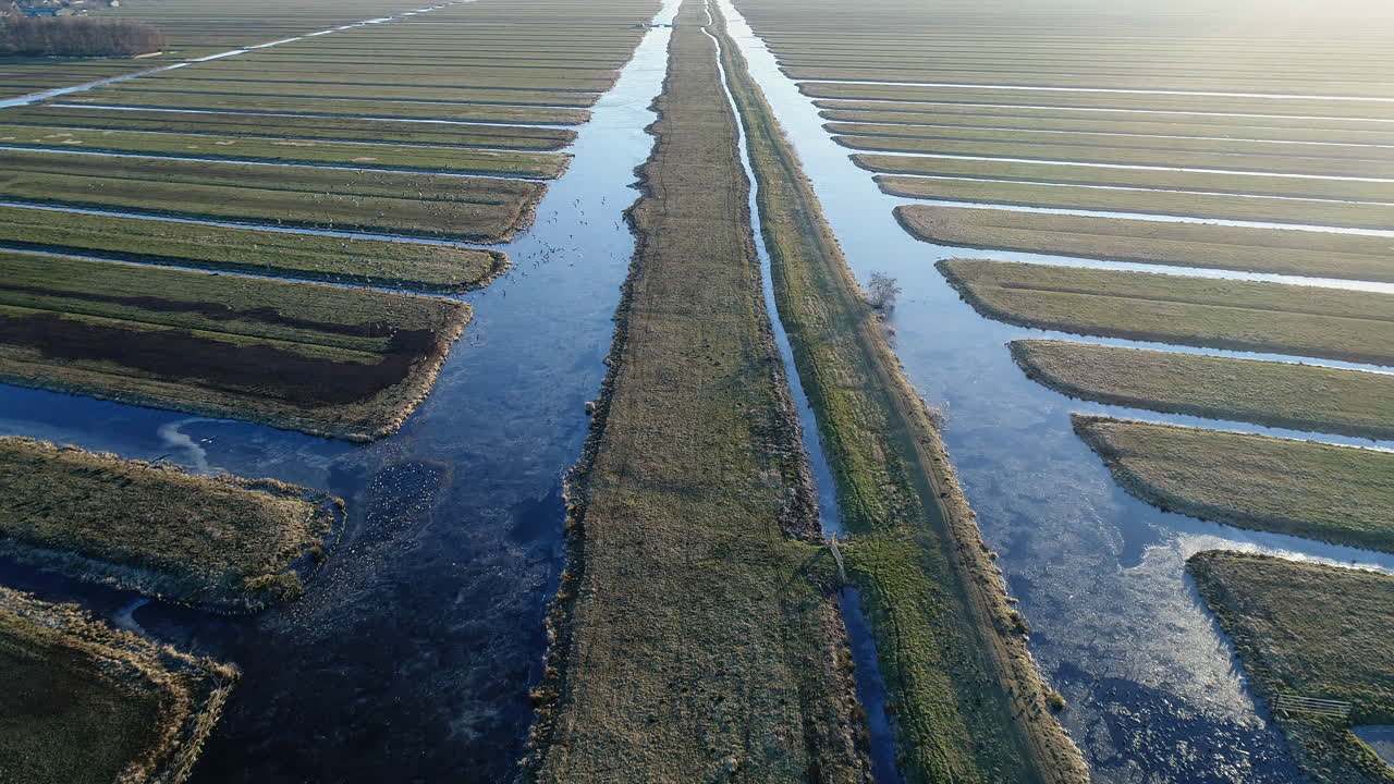 Luftfoto af en frossen grøft om vinteren ved solopgang i Krimpenerwaard, Stolwijk, Holland