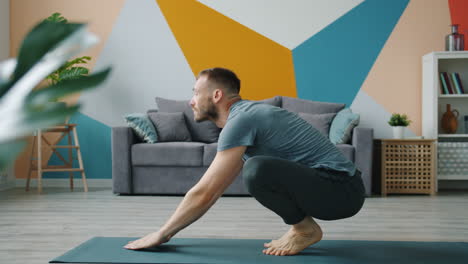 man practicing yoga poses at home