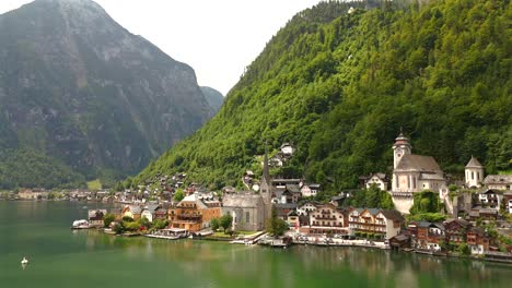 aerial view of hallstatt, austria, captured by drone, showcasing its picturesque lakeside homes, majestic mountains, and the unique charm of this enchanting alpine village.