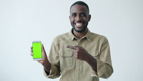 man showing a green screen phone