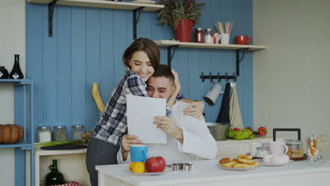 couple celebrating good news in the kitchen