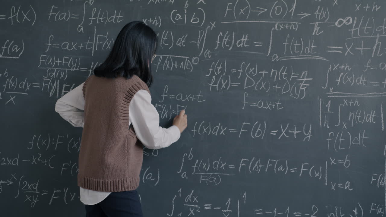 Woman Writing Equations on Blackboard
