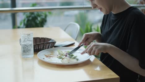 woman eating salad in a cafe