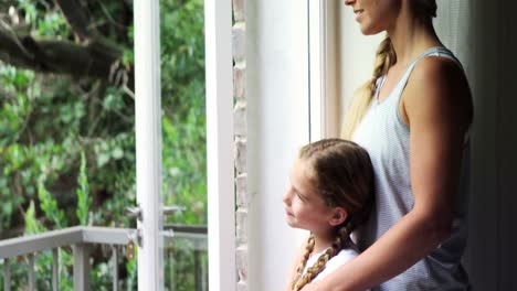 Mother-and-daughter-looking-through-window-in-bedroom-4k